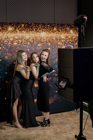 „Absolvenți făcând poze la căsuța foto închiriată de la Absolvire.shop la o festivitate de absolvire”